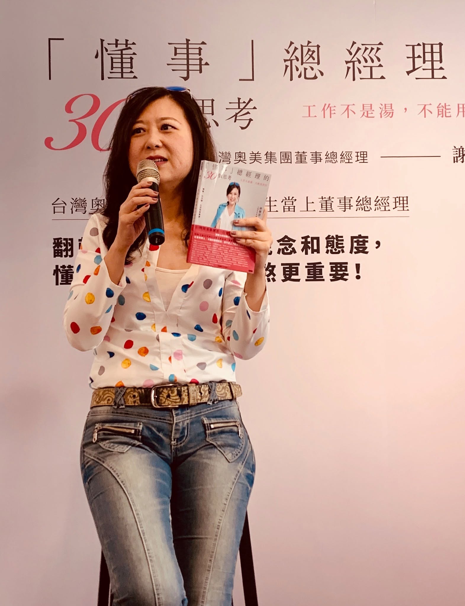 Abby 拿著書在講座中分享